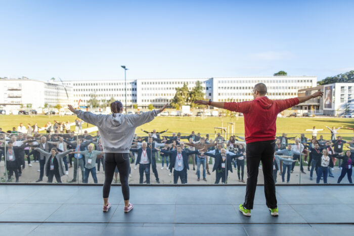Groupe de managers faisant un réveil musculaire dans l'herbe de Nancy Thermal à Nancy